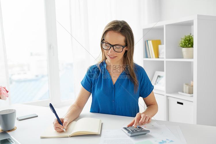 商业人财务会计快乐的女人与计算器计数写作笔记本办公室办公室里计算